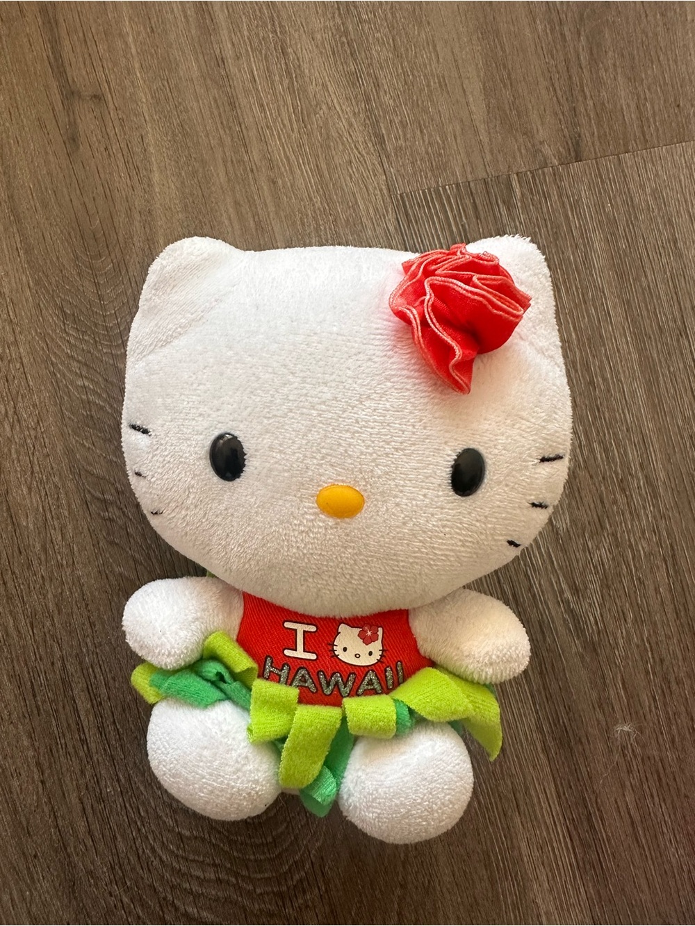 White Hello Kitty Plush Toy with Red Bow and Green Skirt
